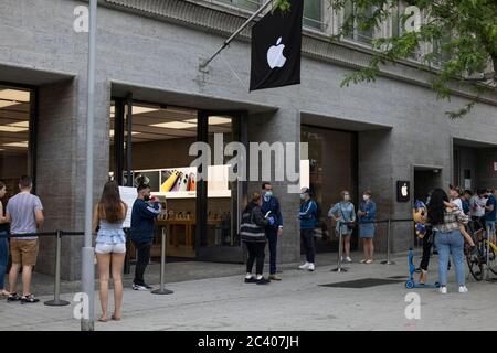 Les clients font la queue en portant des masques dans une file d'attente sociale à l'extérieur d'un magasin Apple Store dans le centre de Hanovre, en Allemagne Banque D'Images