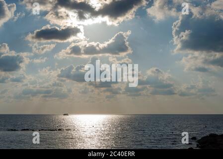 Des nuages lourds et sombres couvraient le ciel bleu sur la mer Méditerranée. Nuages de pluie durs. Faisceau de soleil à travers le ciel lourd, paysage urbain. Banque D'Images