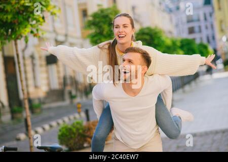Jeune femme à cheval sur le dos d'un homme Banque D'Images