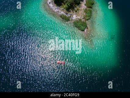 23 juin 2020, Bavière, Grainau: Les excursions prennent un pédalo sur l'Eibsee, chatoyant dans différentes nuances de bleu, au-delà de petites îles (vue aérienne avec un drone). Photo: Sven Hoppe/dpa Banque D'Images