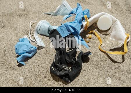 Masque et gants en plastique, déchets médicaux jetables sur la côte de mer, pollution covid Banque D'Images