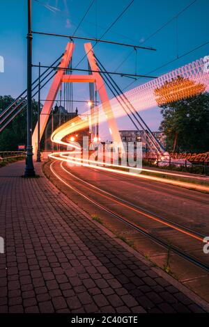 Trafic ferroviaire de nuit sur le pont Wladyslaw Jagiello à Bydgoszcz. Paysage de la ville de Niht. Exposition longue. Banque D'Images