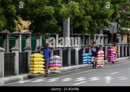 Manille. 23 juin 2020. Les hommes portant des masques portent des oreillers en vente sur un marché de Manille, aux Philippines, le 23 juin 2020. Le nombre de cas de COVID-19 aux Philippines est passé à 31,825 après que le ministère de la Santé (DOH) a signalé un record de 1,150 autres infections mardi. Crédit: Rouelle Umali/Xinhua/Alay Live News Banque D'Images