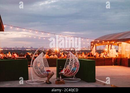 personnes assistant à une fête d'été en plein air sur le toit en soirée Banque D'Images