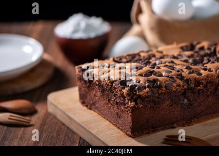 Gâteau éponge traditionnel taïwanais au goût de chocolat (taïwanais castella kasutera) sur une table de fond en plateau de bois avec les ingrédients, gros plan. Banque D'Images