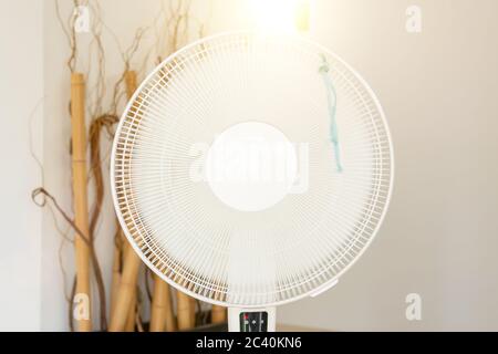 Gros plan sur le ventilateur au sol électrique en action dans l'intérieur moderne de la maison pendant la chaude journée ensoleillée d'été Banque D'Images