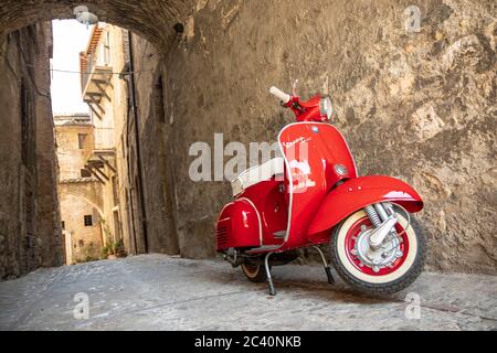 30 juin 2019 - Rome, Latium, Italie - UN Piaggio Vespa Sprint rouge, garée dans une allée d'un ancien village, en Italie. Le symbole de scooter de l'italien Banque D'Images