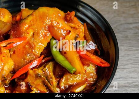 Poulet frit cuit avec une sauce aigre-douce épicée, Chili thaïlandais, piment rouge et pommes de terre. Banque D'Images
