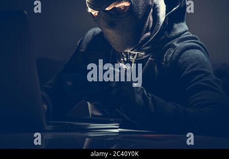 Achats en ligne de pirates masqués et de cartes de crédit volées. Concept de cyber-sécurité. Banque D'Images