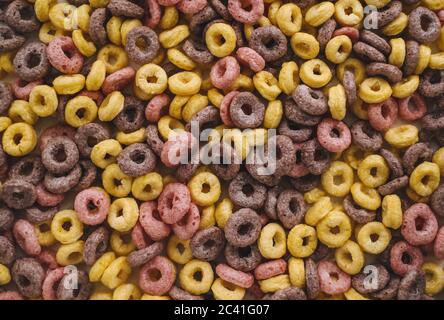 Anneaux de maïs multicolores pour le petit déjeuner, fond texturé. Banque D'Images