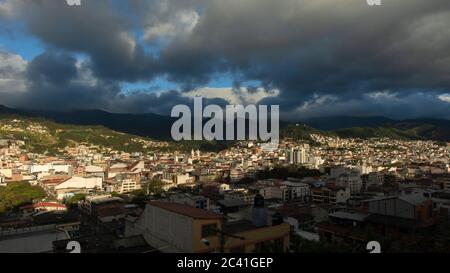 Vue panoramique de la ville de Loja en Equateur avec des montagnes à l'horizon, un après-midi nuageux avant la tempête Banque D'Images