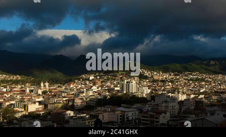 Vue panoramique de la ville de Loja en Equateur avec des montagnes à l'horizon, un après-midi nuageux avant la tempête Banque D'Images