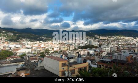 Vue panoramique de la ville de Loja en Equateur avec des montagnes à l'horizon, un après-midi nuageux avant la tempête Banque D'Images