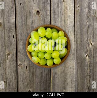 Raisins dans un bol en bois. Raisins verts Kis Mish sur un fond de bois. Vue d'en haut. Banque D'Images