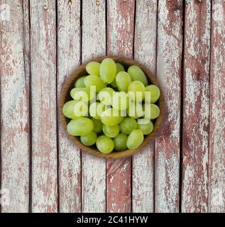 Raisins dans un bol en bois. Raisins verts Kis Mish sur un fond de bois. Vue d'en haut. Banque D'Images