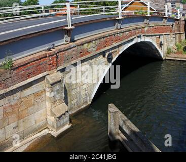 Vue sur le côté sud-est du pont routier médiéval au-dessus de la rivière Bure sur les Norfolk Broads à Wroxham, Norfolk, Angleterre, Royaume-Uni. Banque D'Images