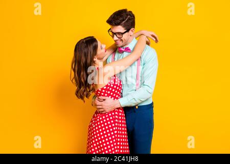 Portrait de positif passionné couple fille gars câlin embrasser cuddle apprécier amour porter rouge pointillés robe bretelles pantalon pantalons isolé Banque D'Images