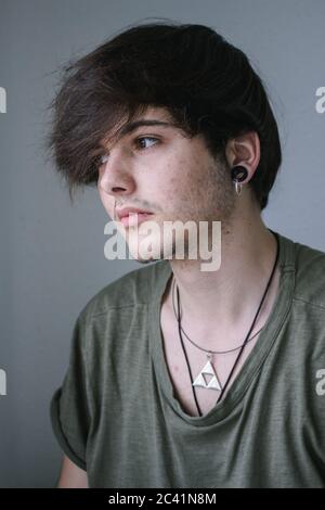 Portrait d'un jeune garçon avec collier et boucles d'oreilles. Banque D'Images