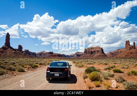 Voiture sur une route de terre dans un paysage désertique pittoresque avec des rochers en arrière-plan Banque D'Images