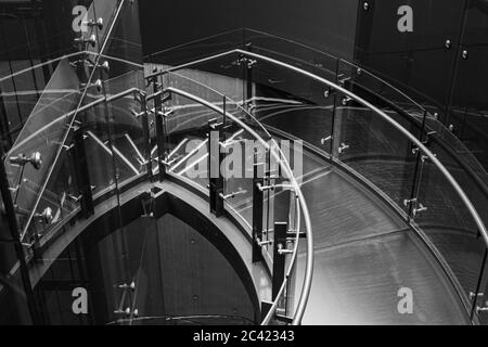 Image en noir et blanc d'un escalier descendant en acier et en verre à l'édifice Telus de Vancouver, en Colombie-Britannique Banque D'Images