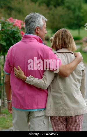 Couple âgé marche bras dans bras dans le parc - loisir - détente Banque D'Images