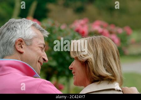 Couple senior marche bras dans bras dans le parc - loisirs - détente Banque D'Images