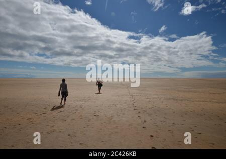Deux personnes se promètent à l'horizon sur la plage de Raudasandur en Islande Banque D'Images