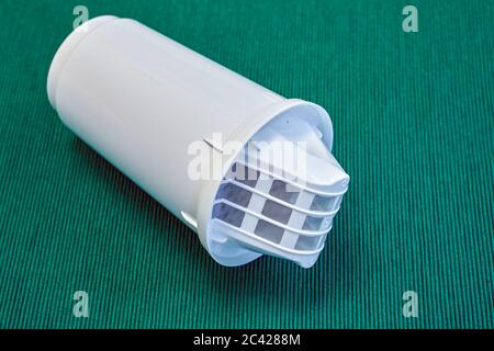 Module remplaçable ou cartouche pour nettoyer l'eau du robinet dans une verseuse isotherme, sur fond vert. Substances absorbantes dans un boîtier en plastique. Banque D'Images