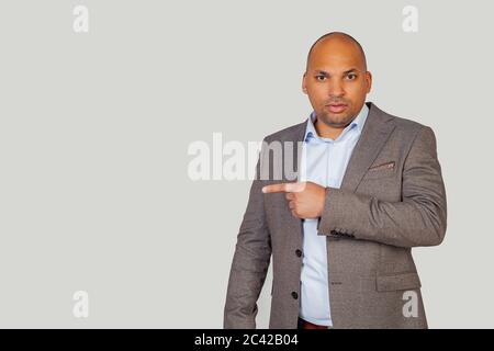Impressionné le jeune homme afro-américain gars pointant du côté avec l'expression du visage surprise. Copier l'espace publicitaire. Banque D'Images