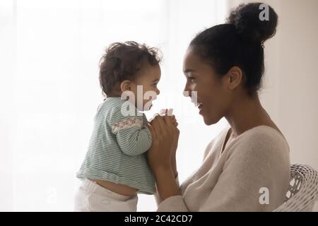 Bonne mère africaine américaine et petite fille appréciant le moment d'appel d'offres