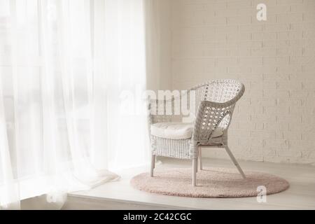 Fauteuil en osier blanc dans une chambre moderne vide avec moquette Banque D'Images