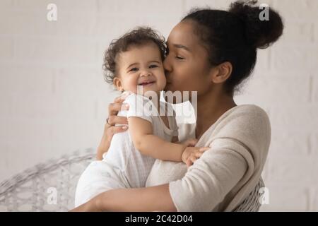 Gros plan amour jeune mère afro-américaine embrassant petite fille Banque D'Images