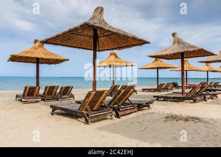 Mer Noire, Roumanie. Parasols en paille sur la plage de Mamaia. Banque D'Images