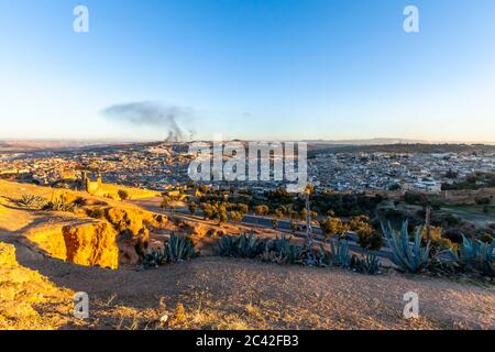 Vue sur Fès depuis les tombes du Marinid. En arrière-plan, vous pouvez voir les colonnes de fumée des fours à briques Banque D'Images