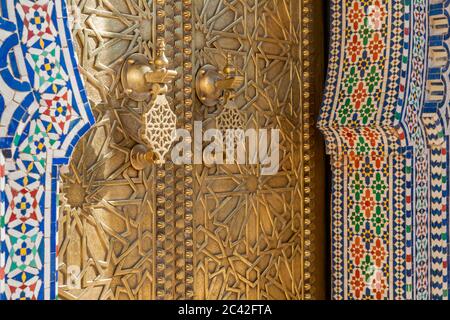 Porte-sonnant en laiton et mosaïques du palais royal de Fès. Les portes en bois du mur autour du palais royal entre 1961 et 1968 sont décorées de travaux en laiton Banque D'Images