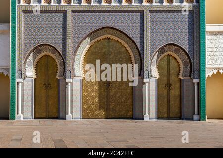 Porte-sonnant en laiton et mosaïques du palais royal de Fès. Les portes en bois du mur autour du palais royal entre 1961 et 1968 sont décorées de travaux en laiton Banque D'Images