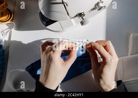 De haut talentueux artisan femme couture morceau de caoutchouc bande tout en travaillant en studio Banque D'Images