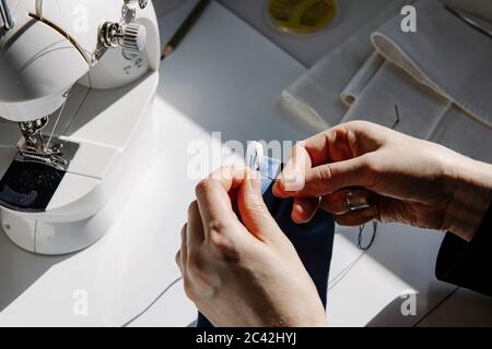 De haut talentueux artisan femme couture morceau de caoutchouc bande tout en travaillant en studio Banque D'Images
