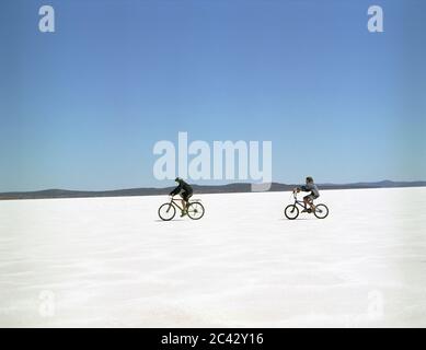 Deux enfants font du vélo dans l'Outback, en Australie Banque D'Images