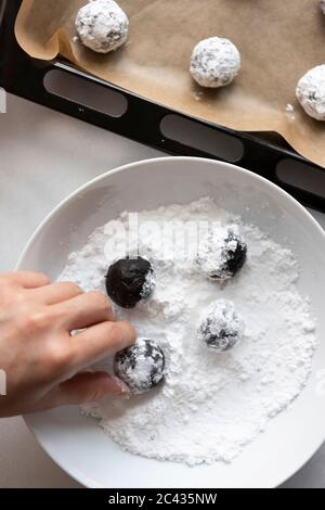 Boulettes de biscuit au chocolat dans un bol de sucre en poudre Banque D'Images