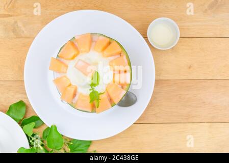 Melon Bingsu avec Lait condensé Sucré sur table en bois Banque D'Images