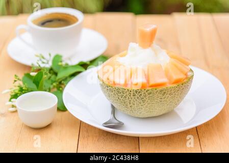 Melon Bingsu avec Lait condensé Sucré sur table en bois Banque D'Images