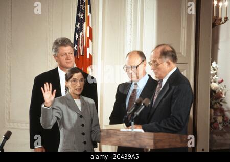 La juge associée de la Cour suprême Ruth Bader Ginsburg, au centre gauche, est assermentée par le juge en chef des États-Unis William H. Rehnquist, à droite, lors d'une cérémonie dans la salle est de la Maison Blanche à Washington, DC, le 10 août 1993. LE président AMÉRICAIN Bill Clinton, à gauche, et Martin Ginsburg, au centre-droit, regardent. Le juge Ginsburg remplace le juge associé Byron R. White.Credit: Arnie Sachs / CNP /MediaPunch Banque D'Images