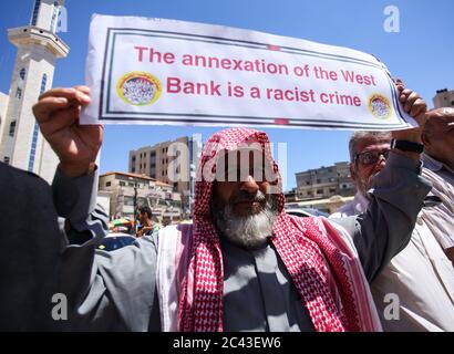 Khan Yunis, Palestine. 23 juin 2020. Un palestinien détient une plaque lors d'une manifestation contre Israël qui prévoit d'annexer des parties de la Cisjordanie occupée, à Khan Yunis, dans le sud de la bande de Gaza, en Palestine, le 23 juin 2020. Israël entend entamer un processus d’annexion des colonies de Cisjordanie et de la vallée du Jourdain à partir du 1er juillet, dans le cadre d’une initiative de paix américaine. (Photo par Yousef Masoud/INA photo Agency/Sipa USA) crédit: SIPA USA/Alay Live News Banque D'Images