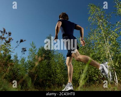 Homme jogging dans une zone rurale, Munich, Bavière, Allemagne Banque D'Images