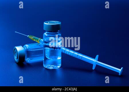Vaccins, toxine botulinique et ampoules d'insuline concept thème avec des flacons en verre avec liquide clair à côté d'une seringue et une aiguille hypodermique isolée sur b Banque D'Images