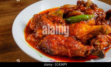 Ayam masak merah est un plat traditionnel malaisien. Cela signifie littéralement « cuit-rouge » de poulet en anglais. C'est une cocotte de morceaux de poulet en c séché Banque D'Images