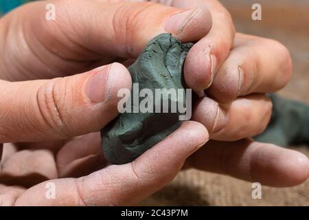 argile brute bleue dans les mains des femmes Banque D'Images