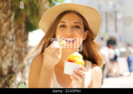 Gros plan de la jolie fille touristique qui mange de la glace traditionnelle italienne à Sirmione, Italie Banque D'Images