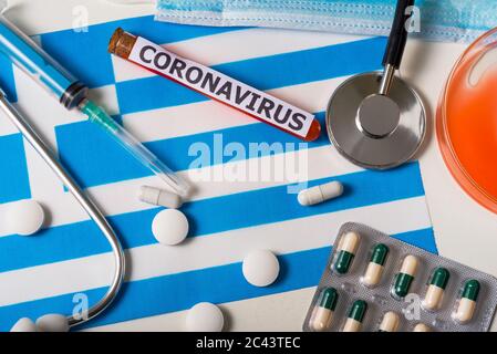 Coronavirus, concept nCoV. Vue du haut masque respiratoire protecteur, stéthoscope, seringue, pilules sur le drapeau de la Grèce. Une nouvelle épidémie de la couronne chinoise Banque D'Images